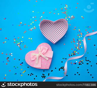 open pink heart-shaped cardboard box on a pink background with multi-colored shiny confetti, festive backdrop for birthday, Valentine&rsquo;s day