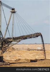 Open pit. Opencast brown coal mine. Giant excavator machinery. Extractive industry.