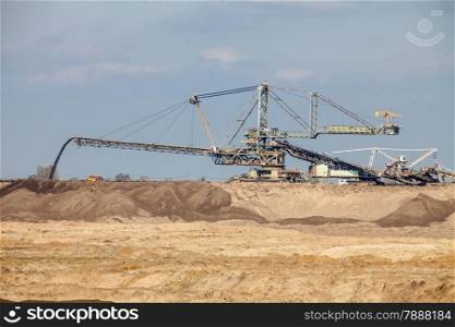 Open pit. Opencast brown coal mine. Giant excavator machinery. Extractive industry.
