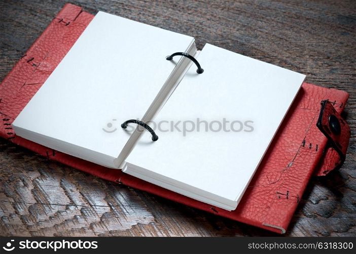 Open Red Notebook on the wooden background