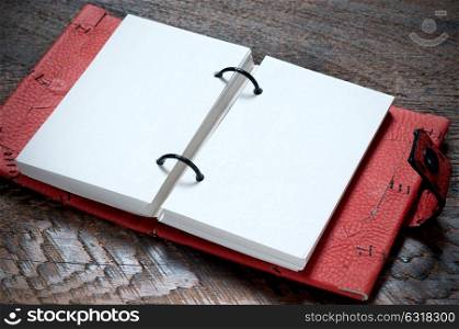 Open Red Notebook on the wooden background