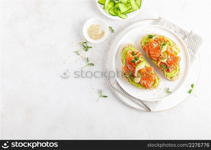 Open sandwiches with salted salmon, guacamole avocado and microgreens. Seafood. Healthy food. Top view.