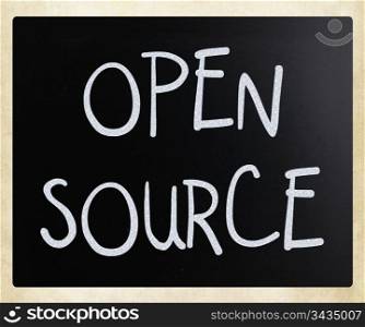 ""Open source" handwritten with white chalk on a blackboard."
