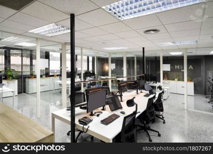 Open space office with computer monitors on white desks