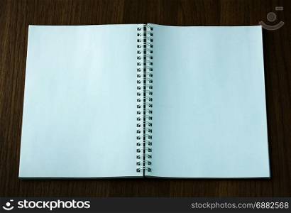 open spiral notebook on dark wood background