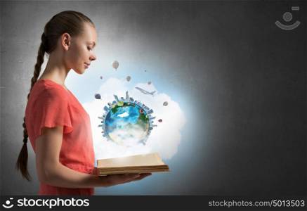 Open the whole world for yourself. Young woman in dress holding opened book. Elements of this image are furnished by NASA