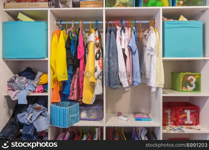 Open wardrobe with things and toys in the children&rsquo;s room