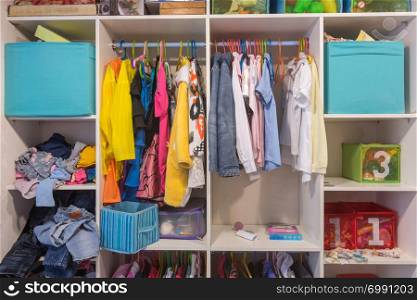 Open wardrobe with things and toys in the children&rsquo;s room