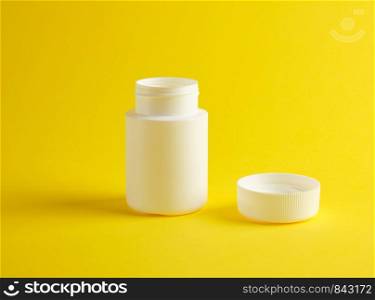 open white plastic jar for medicines stands on a yellow background, blank for design and inscription