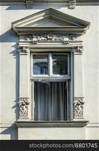 Open window decorated with bas-relief, old gray building in Lviv (Lvov), Ukraine
