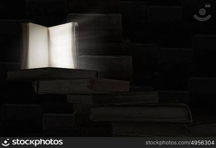 Opened book. Old opened book with light coming from pages on dark background.