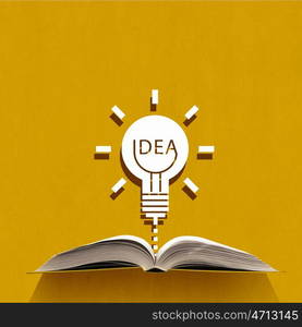 Opened book on color background. Opened book and idea light bulb on pages