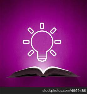 Opened book on color background. Opened book and idea light bulb on pages