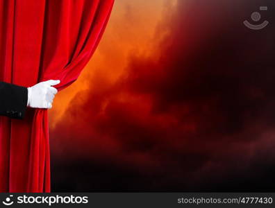 Opened curtain. Human hand in white glove opening red velvet curtain