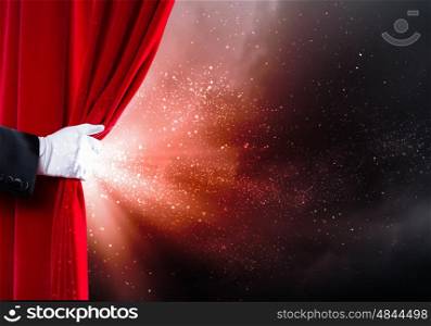 Opened curtain. Human hand in white glove opening red velvet curtain