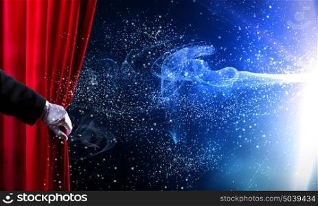 Opened curtain. Human hand in white glove opening red velvet curtain