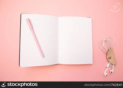 Opened empty diary with pink pen on pastel millennial pink paper background. Concept education, blogging. Top view. Flat lay. Minimal style. Template for female blog. Lifestyle. Copy space.