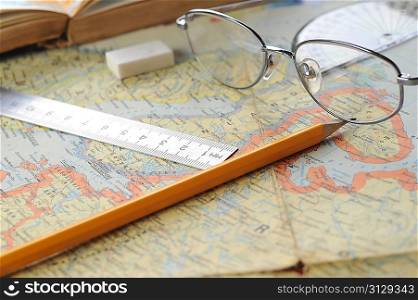 opened old atlas book on map and glasses