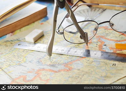 opened old atlas book on map and glasses