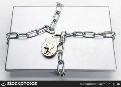 opened padlock with key and chain wrapped around closed laptop computer