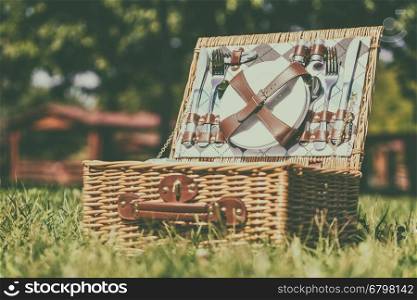 Opened Picnic Basket With Cutlery In Spring Green Grass