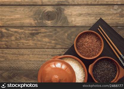 opened pot bowls with different type rice grains wooden table