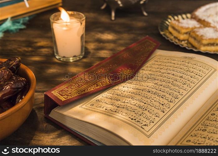 opened quran near candle sweet dates . Resolution and high quality beautiful photo. opened quran near candle sweet dates . High quality and resolution beautiful photo concept