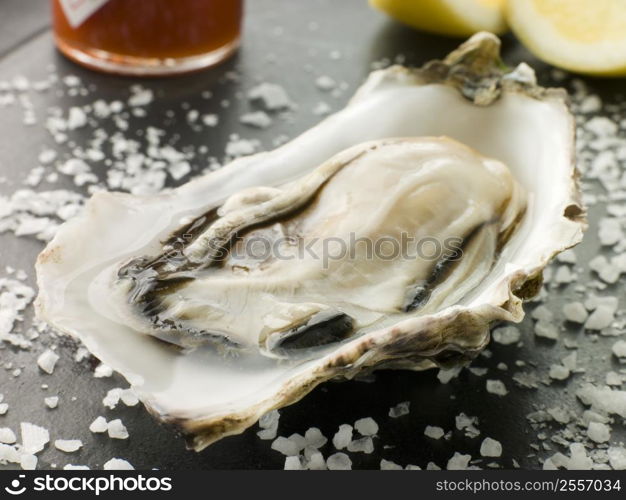 Opened Rock Oyster with Hot Chilli Sauce Lemon and Sea Salt