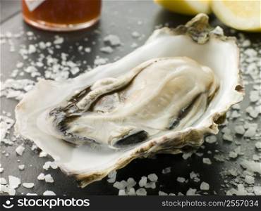 Opened Rock Oyster with Hot Chilli Sauce Lemon and Sea Salt