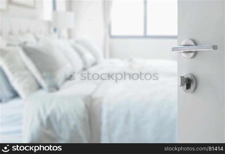 opened white door to abstract background of classic white bedroom interior