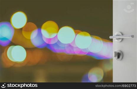 opened white door to abstract background with bokeh defocused lights and shadow from cityscape at night