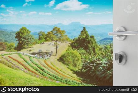 opened white door to beautiful landscape with mountain and flower from viewpoint of huay nam dung national park , Chiangmai , Thailand
