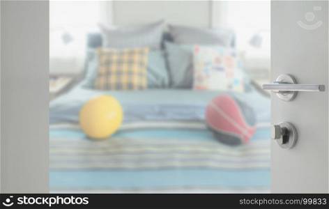 opened white door to bedroom with decorative pillow and football on bed