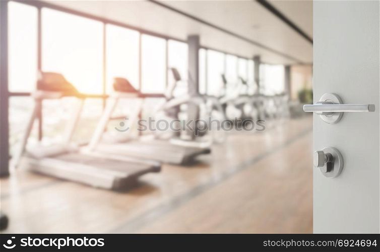 opened white door to fitness or gym room interior