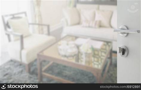 opened white door to living room interior with set of elegant teacup