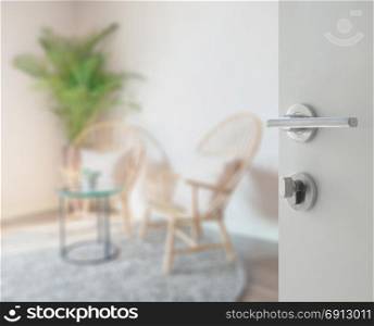 opened white door to living room interior with wooden chair as background