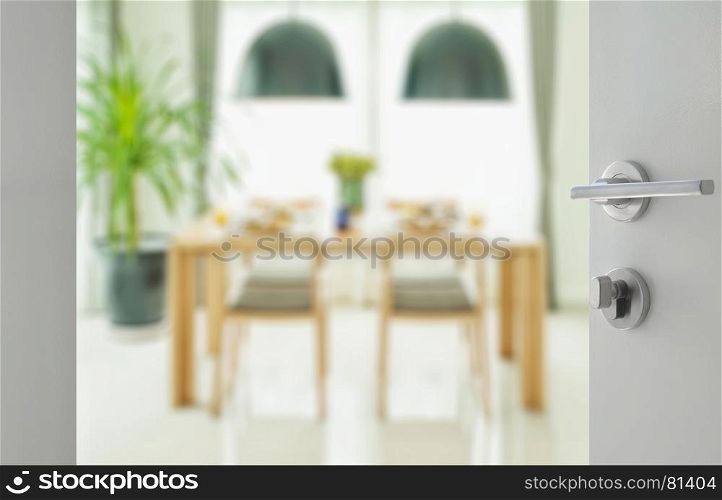 opened white door to wooden dining table and chairs with elegant table setting