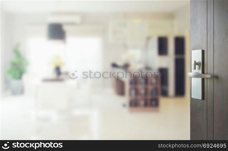 opened wooden door to blurred interior background of modern dining room with pantry.