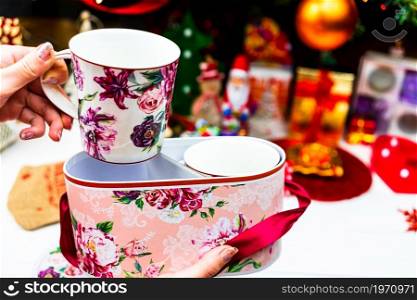 Opening a Christmas present. Christmas mugs