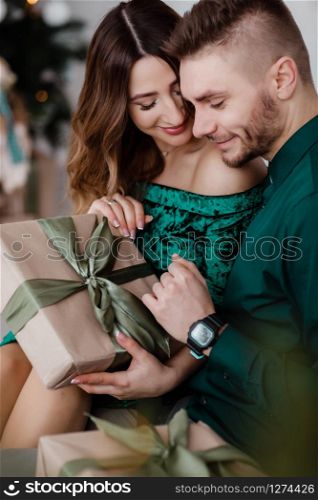 Opening christmas present. Couple in love happy enjoy christmas holiday celebration. Loving couple cuddle smiling while unpacking gift christmas tree background.What a surprise. Opening christmas present. Couple in love happy enjoy christmas holiday celebration. Loving couple cuddle smiling while unpacking gift christmas tree background.What a surprise.