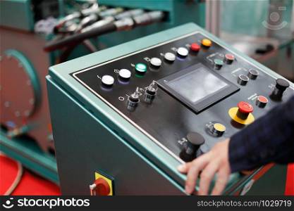 Operator working with a control panel of modern metalworking machine. Selective focus.