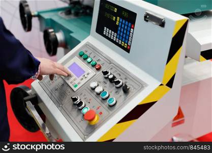 Operator working with control panel of cnc turning and milling machine. Selective focus.