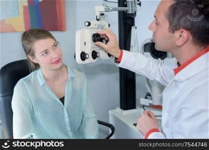 ophthalmologist talking to young woman in clinic