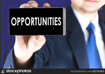 Opportunities word on mobile phone screen in blurred young businessman hand and digital technology background