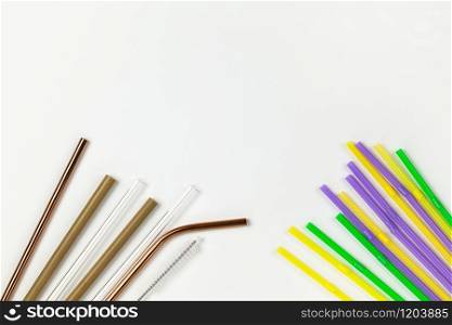 Opposition of plastic disposable tubes and environmental metal, glass, bamboo. Alternative to disposable tableware concept. White background. Horizontal. Copy space. Flat lay, close-up, top veiw.