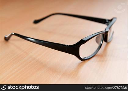 Optical glasses on wooden background