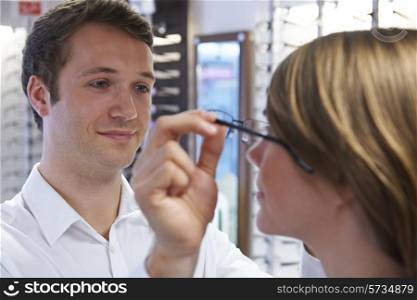 Optician Advising Client On Choice Of Glasses
