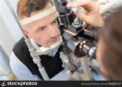 optician checking patient's eyes