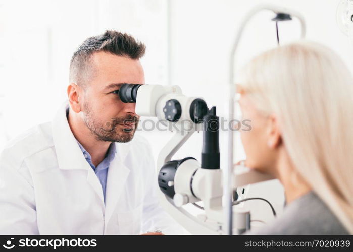 Optician examining his patients eyesight. Healthcare, professional medical equipment.. Optician examining his patients eyesight.