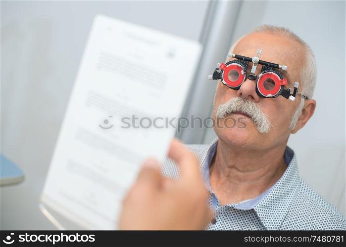 optician in surgery giving man eye test